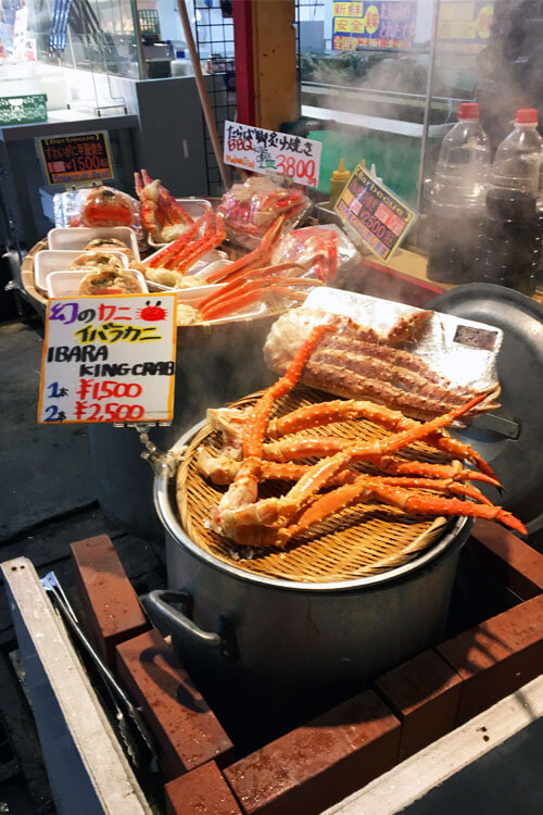 King crab legs being steamed outside of a small seafood shop in Otaru.