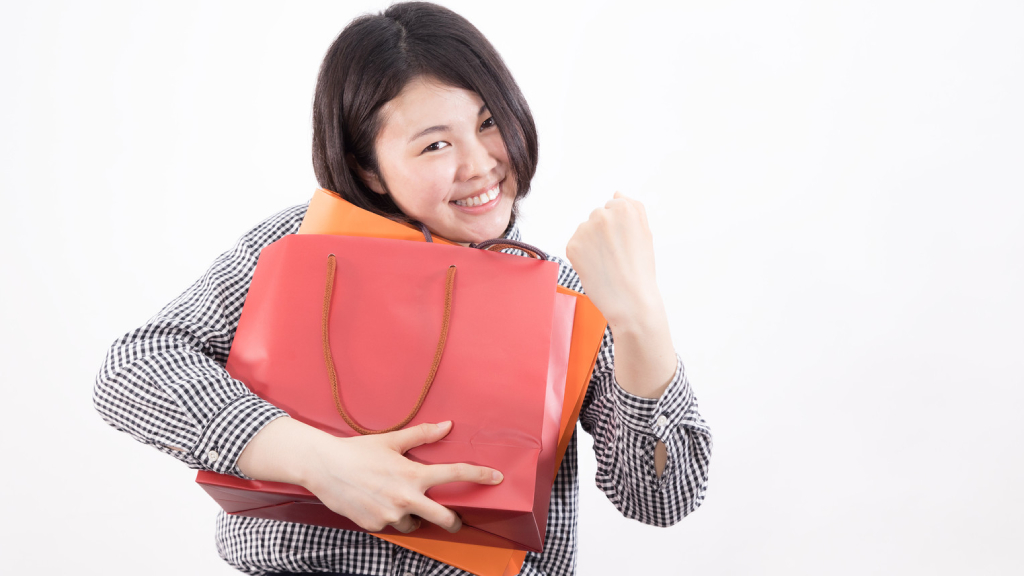 Woman holding two purses and smiling.