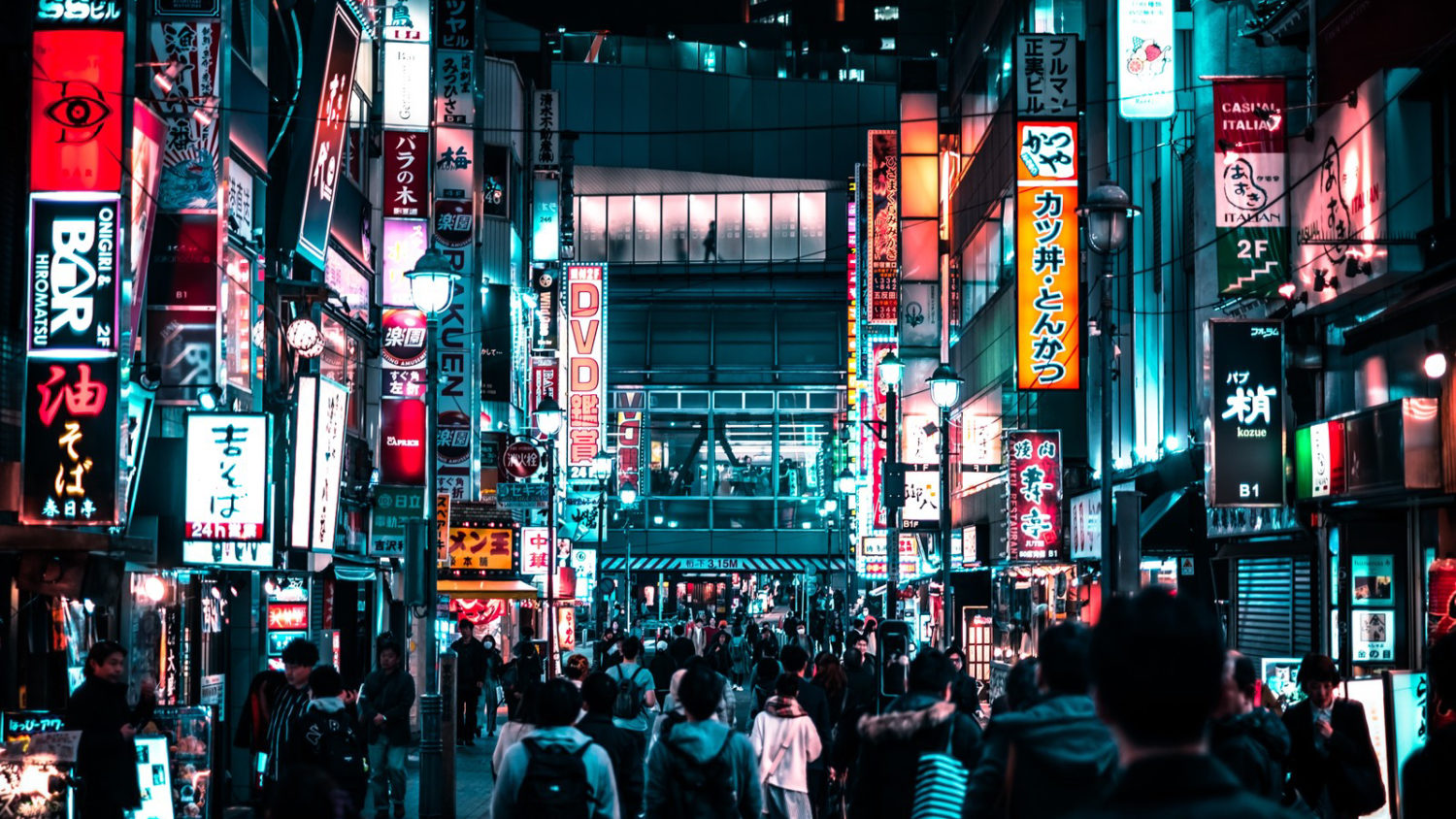Night view of a crowded Tokyo street with many illuminated signs.